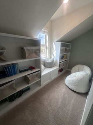 Model Home A charming kids' bedroom with a rustic wood-frame bed, soft carpet, and natural light from large windows in Dacula, GA.