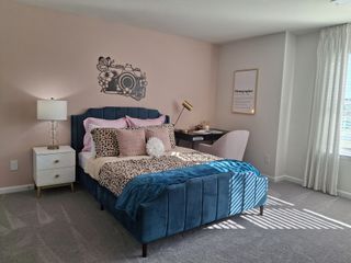 A chic bedroom with a velvet bed, leopard-print accents, and a cozy workspace by the window.