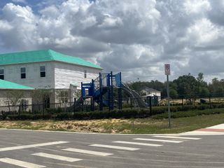A developing home with turquoise roofing near a playground in Meadowlark Landing by Mattamy Homes (Apopka, FL).