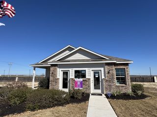 Street view A charming brick home with a landscaped yard in Dauer Ranch by Legend Homes (New Braunfels, TX).
