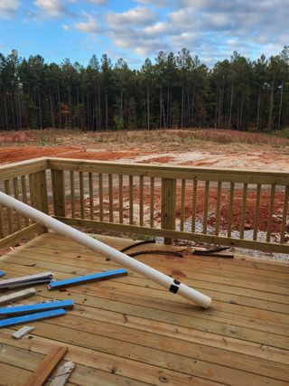 Street view A scenic view of a rustic deck overlooking a wooded landscape in Olde Place by RiverWILD Homes (Zebulon, NC).