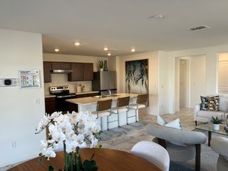 A contemporary open-concept kitchen and living area with modern furnishings, stylish decor, and ample natural light.