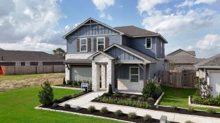 Street view A stunning two-story home with stone and siding accents, lush landscaping, and modern curb appeal in Riverbend at Double Eagle by Meritage Homes (Cedar Creek, TX).
