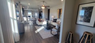 A contemporary living area with sleek wood flooring, cozy seating, and modern decor. Open-concept design with ample natural light.