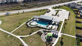 Community Amenities An inviting community pool and playground area in Turner's Village by Meritage Homes (Buda, TX).