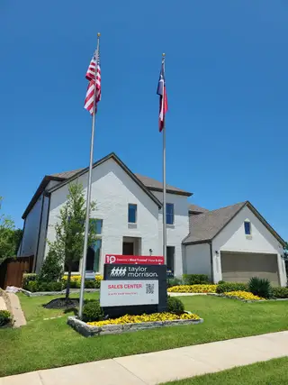 A charming white brick home with lush landscaping in Highland Lakes 60s by Taylor Morrison (McKinney, TX).