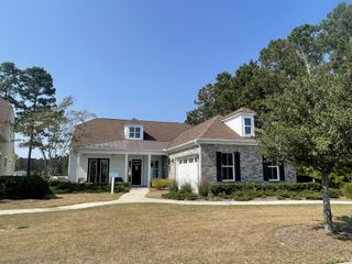 A charming brick and siding home with manicured landscaping in Four Seasons at Lakes of Cane Bay by K. Hovnanian® Homes (Summerville, SC).