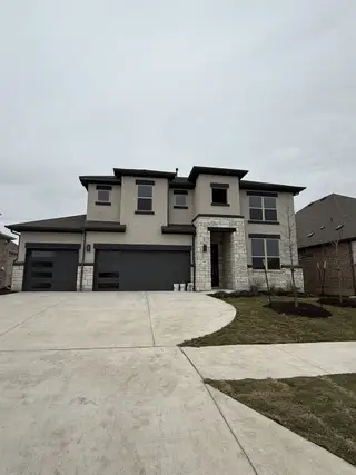 A modern two-story home with sleek stone accents in Hawkes Landing by Brightland Homes (Leander, TX).
