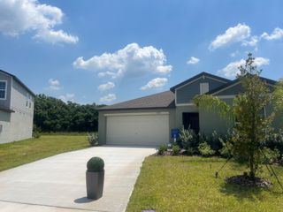 A modern single-story home with a neat lawn in Prosperity Lakes by Lennar (Parrish, FL).
