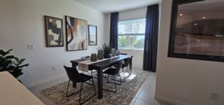 A cozy dining space with natural light, modern artwork, and a chic table setting, perfect for intimate gatherings.