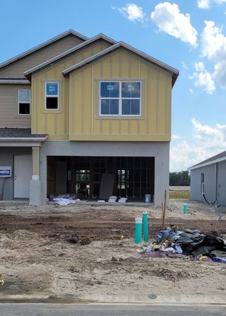 A modern yellow and beige home under construction in Westview: Aden South III by Lennar (Kissimmee, FL).