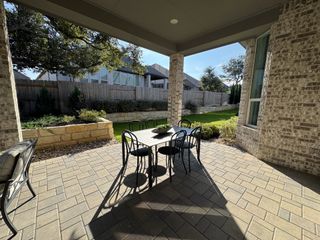 Model Home A spacious outdoor patio with stylish seating and a view of the meticulously maintained backyard.