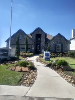 A beautifully designed model home with manicured landscaping and a charming walkway in Westwood by Lennar (League City, TX).
