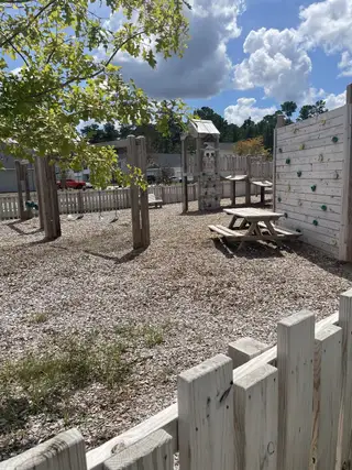 A charming play area with a climbing wall and swings in Petterson Meadows by Mungo Homes (Summerville, SC).