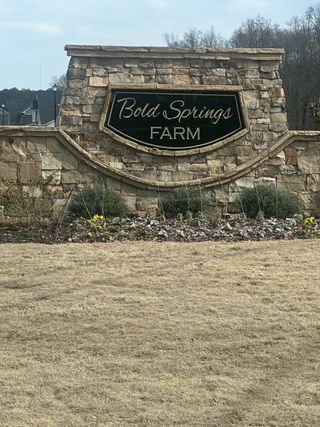  A stone entrance sign for Bold Springs Farm, with a landscaped area featuring small flowers and bushes in (Dacula, GA.