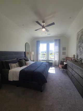 A cozy, modern bedroom with a king-sized bed, elegant decor, and natural light streaming through large windows.