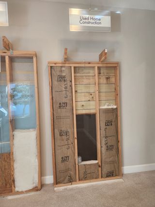 A comparison wall display showcasing insulation and materials used in older home construction, highlighting energy efficiency improvements.