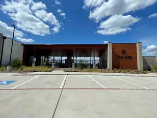 A modern community building with wooden accents and landscaped surroundings in Trillium 60s by Taylor Morrison (Richmond, TX).