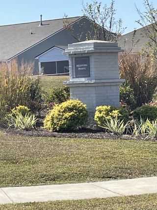 Landscaped entrance with elegant stone sign in Bradford Pointe by Centex, Summerville, SC, showcasing community appeal.