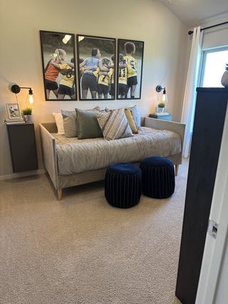 A cozy bedroom with modern decor, featuring a daybed, vibrant wall art, and plush accents creating a welcoming ambiance.