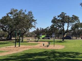 A serene park setting with lush greenery and fitness equipment in Parkside On The River 50' by Perry Homes (Georgetown, TX).