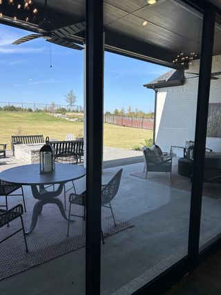 Street view A serene patio view with outdoor seating, overlooking a spacious lawn and clear sky. Perfect for relaxation and entertaining.