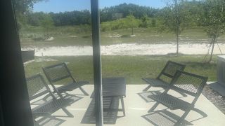 A cozy patio with sleek black chairs overlooking a lush, serene landscape.