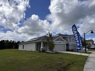 A modern home with solar panels and manicured lawn in Preserve at LPGA by Lennar, Daytona Beach, FL.