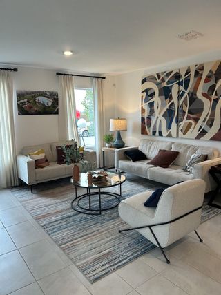 A stylish living room with neutral tones, artistic decor, and natural light.