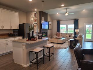 Modern open-concept living area with a sleek kitchen island, cozy seating, and ambient lighting for a warm, inviting atmosphere.