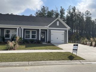 Street view A charming gray home with white trim and manicured lawn in Hammock Walk at Nexton by Ashton Woods (Summerville, SC).
