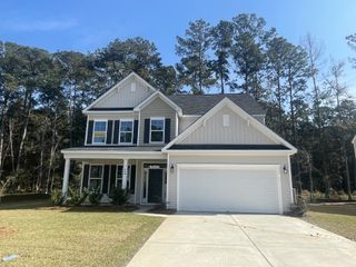 A charming two-story home with a classic facade and lush yard in Ashley Cove by Eastwood Homes (Summerville, SC).