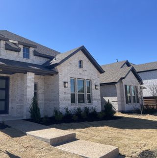 A charming white brick home with modern design in Solterra by HistoryMaker Homes (Mesquite, TX).