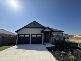 A modern home with dark accents and landscaped front in TRACE by Terrata Homes (San Marcos, TX).
