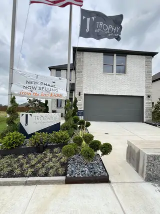 A modern white brick home with elegant landscaping in Southridge by Trophy Signature Homes (McKinney, TX).