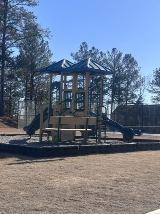 A charming playground with slides and towers in Alcovy Meadows by Resibuilt, nestled in scenic Dacula, GA.