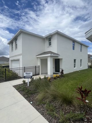 A modern white two-story home with a neat lawn in Ocala Crossings South by D.R. Horton (Ocala, FL).