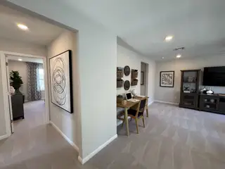 A modern living area with neutral tones, a cozy workspace, abstract artwork, and elegant decor accents.