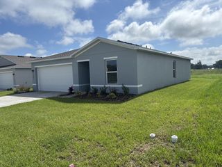 A modern gray home with a spacious yard in Bennah Oaks by Century Complete (Belleview, FL).