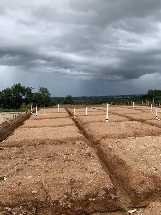 Street view Under construction in Provence by Westin Homes. A cleared site with foundational trenches ready for development in Austin, TX.