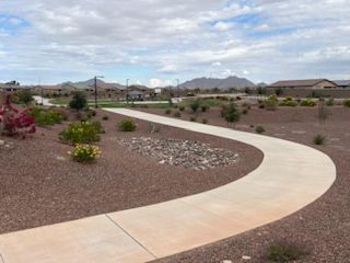 A serene desert landscape with curved paths and mountain views in Arroyo Vista II by KB Home (Casa Grande, AZ).