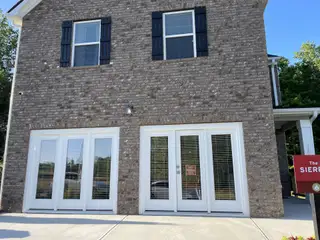 Street view A charming brick home with elegant shutters at Creekbend Overlook by Dream Finders Homes (South Fulton, GA).