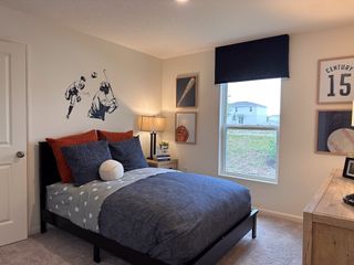 A cozy sports-themed bedroom featuring baseball decor, playful decals, and a large window for ample natural light.