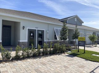 Charming modern home with sleek stone accents and manicured greenery in Orchid Reserve by D.R. Horton (Sebastian, FL).