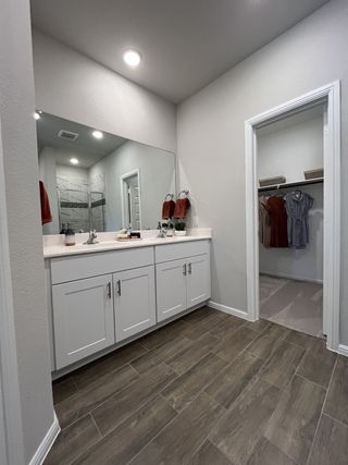 A modern bathroom with dual sinks, sleek white cabinetry, and elegant tile flooring.