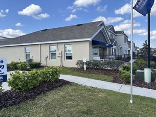 Street view A charming beige home with lush landscaping in Ridge at Heath Brook by D.R. Horton (Ocala, FL).