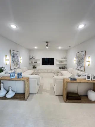 Model Home A spacious living room with cozy white sofas, elegant wall art, ambient lighting, and modern decor elements.