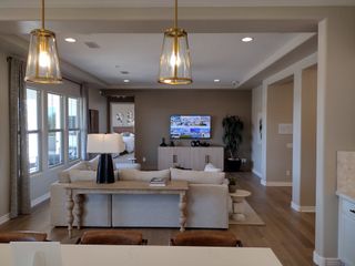 A cozy living room with warm lighting, elegant furnishings, and a wall-mounted TV for perfect relaxation.