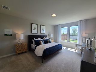 A spacious bedroom with plush carpeting, elegant decor, and large windows offering natural light and serene views.
