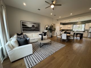 Stylish living space with a white sectional, modern decor, and large windows letting in natural light.